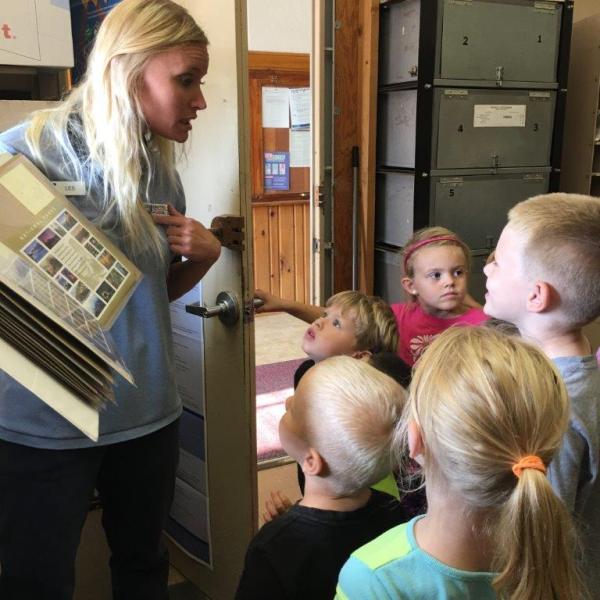 Little River, KS, Retail Associate Leslie Schneider providing a tour of her office to local children.